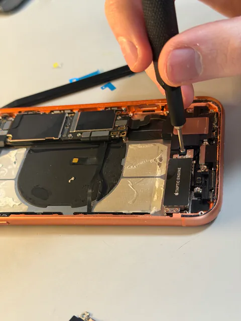 Close-up of an iPhone being repaired with precision tools.